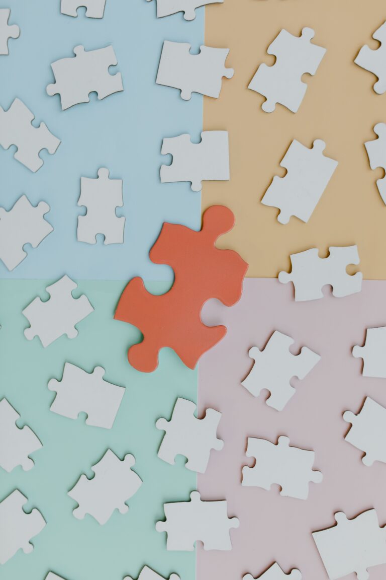 small white puzzle pieces surrounding a big orange one