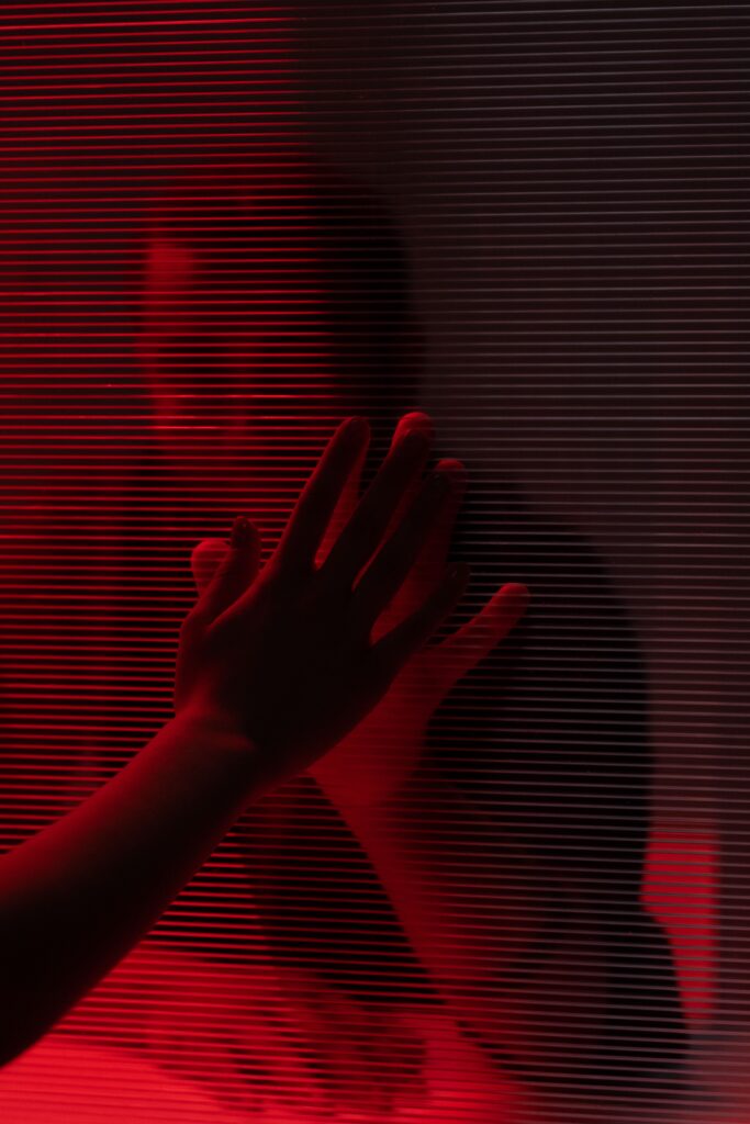 Two hands touching a window from different sides