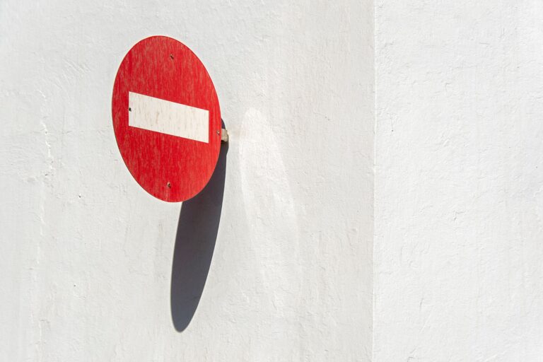 A red stop sign on a white wall