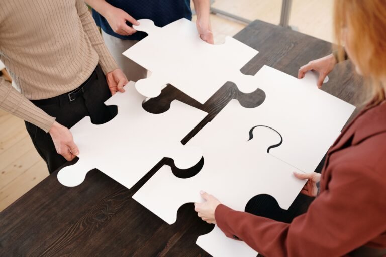 multiple people assembling a huge puzzle