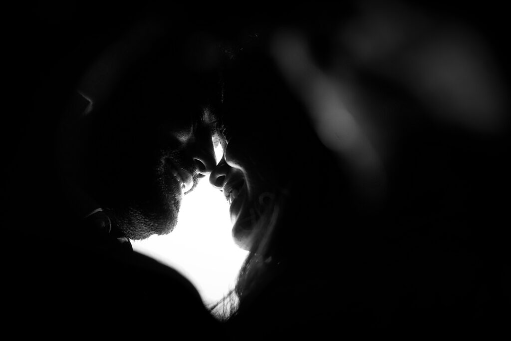 Two black and white faces smiling at each other in a close embrace