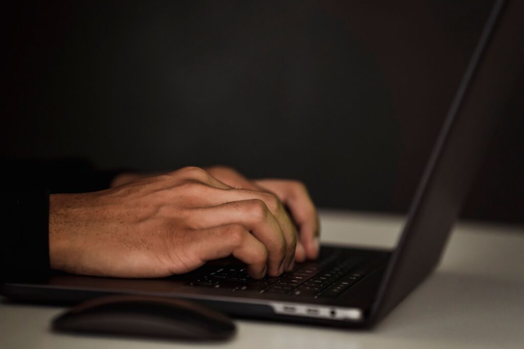 Hand typing away on a laptop
