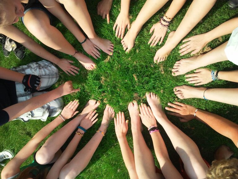 Many hands and feet touching grass