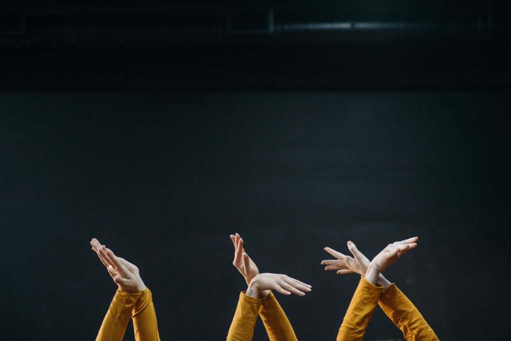 Three pairs of hands crossing themselves