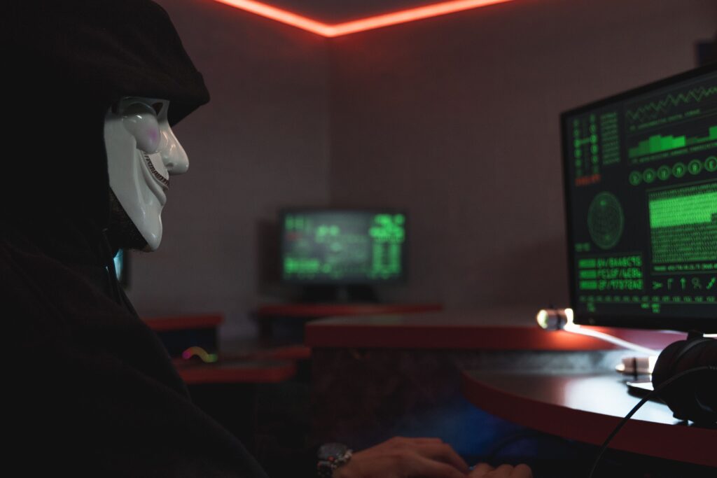 Anonymous hacker working on a computer